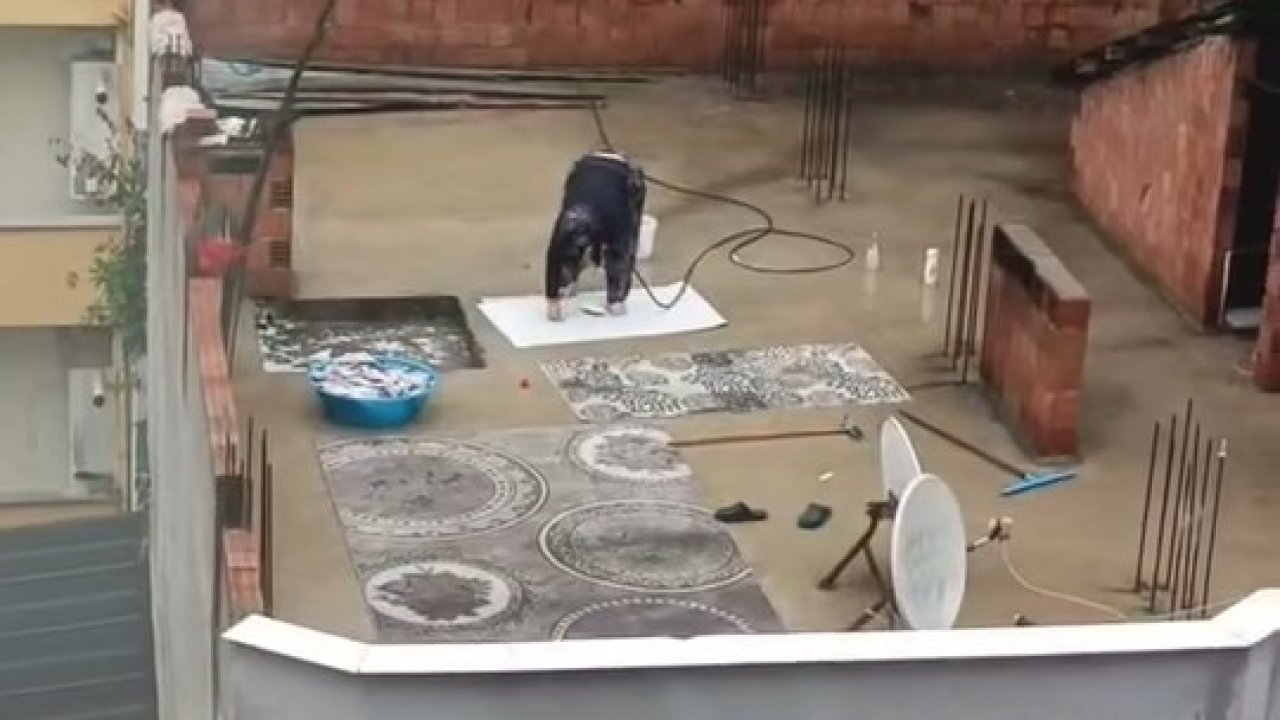 Yağmurlu havada çatıda halı yıkadı, görenler şaştı kaldı
